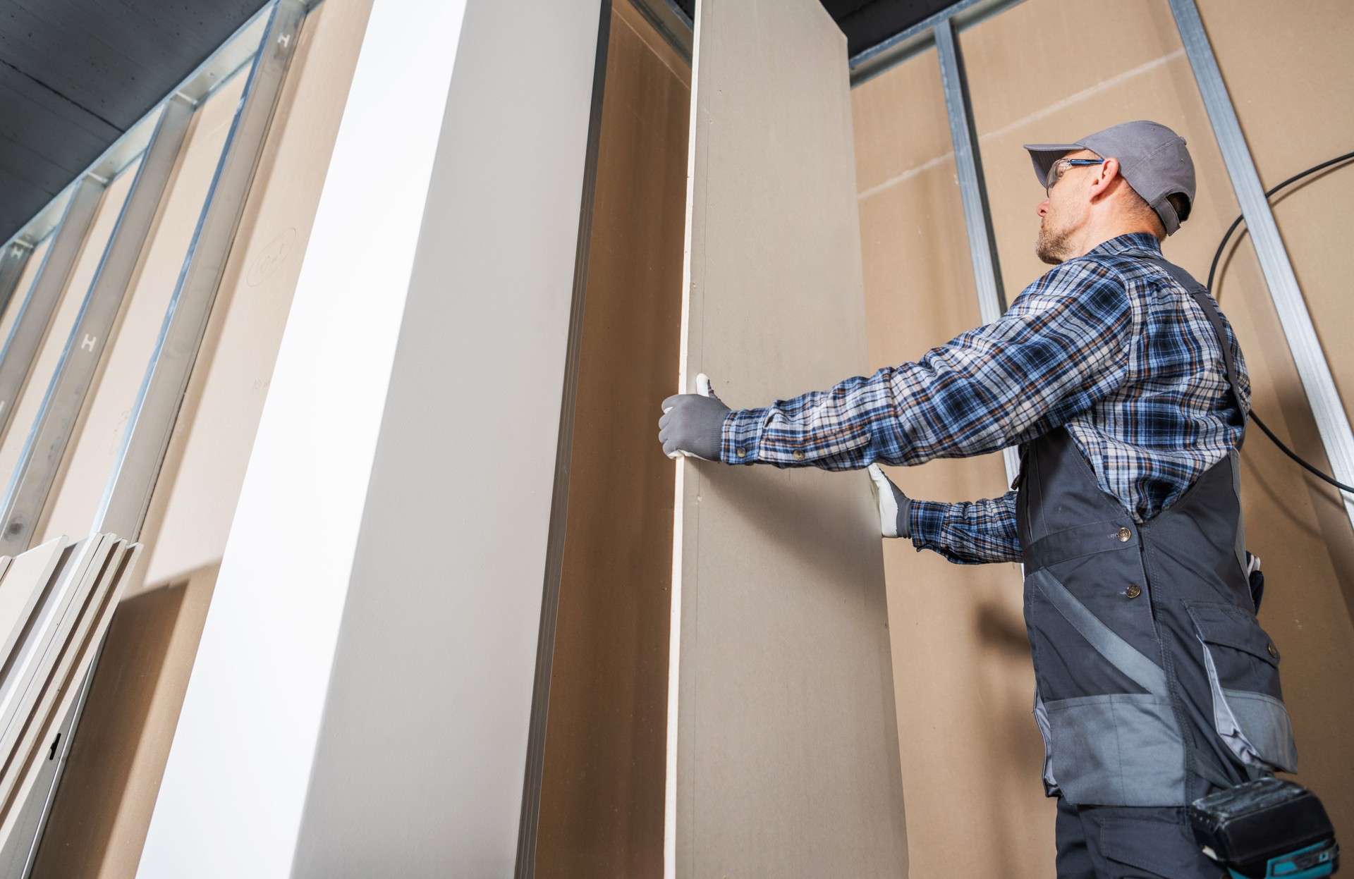 Construction Worker Fitting Piece of a Drywall