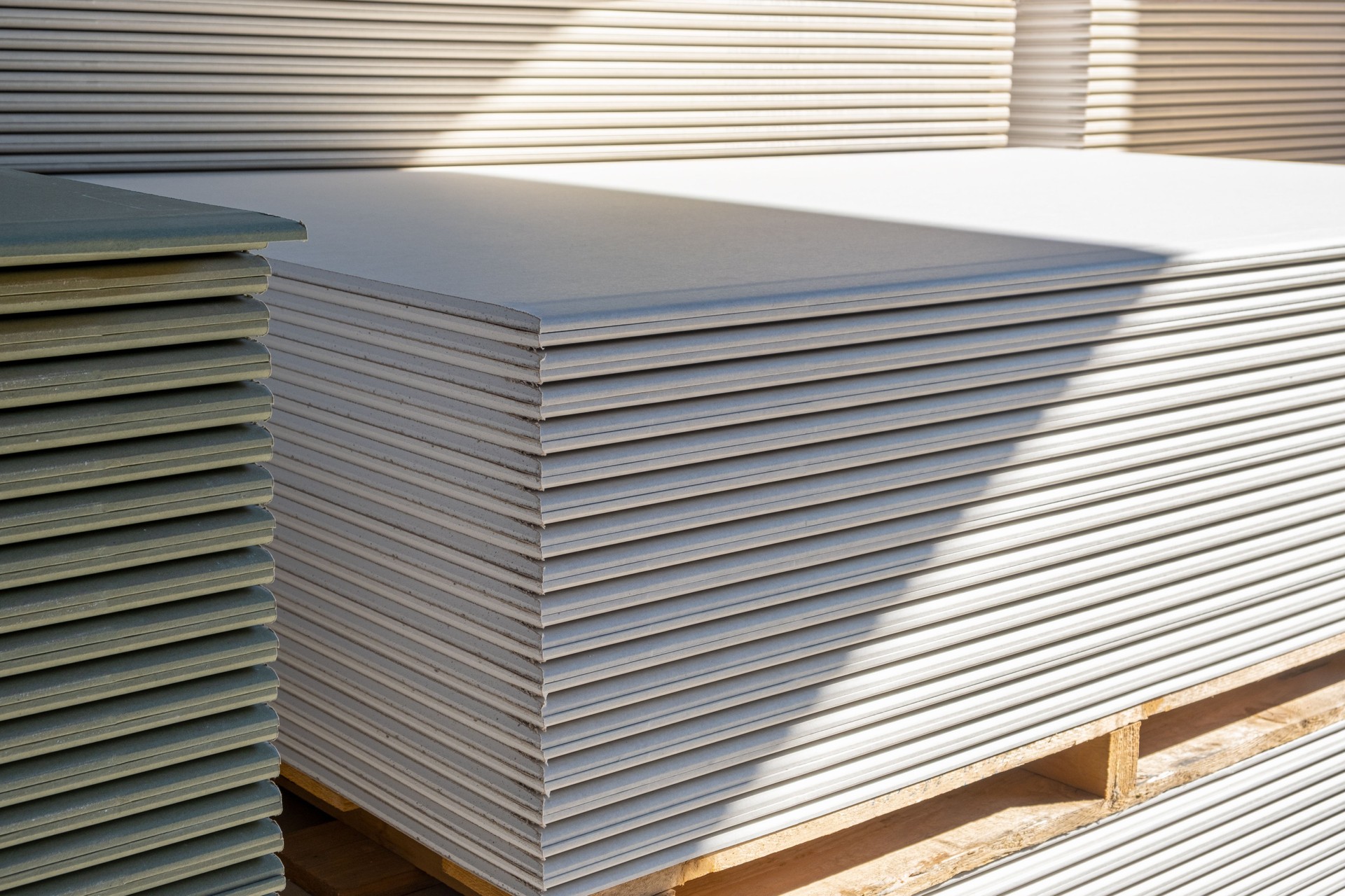 The stack of WHITE drywall Standard Gypsum board panel. Plasterboard. Panel Type A designed for indoor walls, partitions and ceilings, construction site